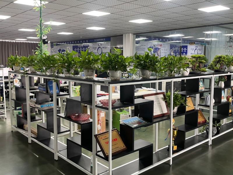Office-interior-with-green-potted-plants-and-awards-displayed-on-black-and-white-shelving-at-LeapPower